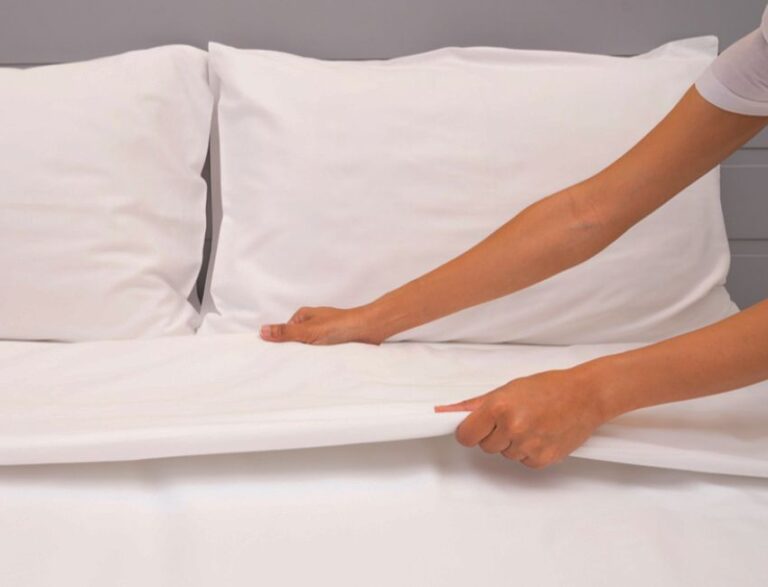 Woman's hands making bed